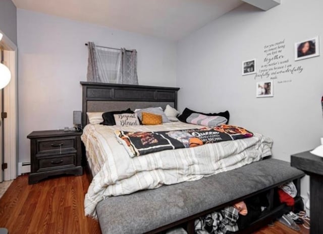 bedroom featuring a baseboard heating unit and dark hardwood / wood-style flooring