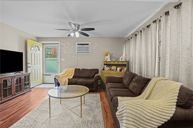 living room featuring a wall mounted AC, dark hardwood / wood-style floors, and ceiling fan