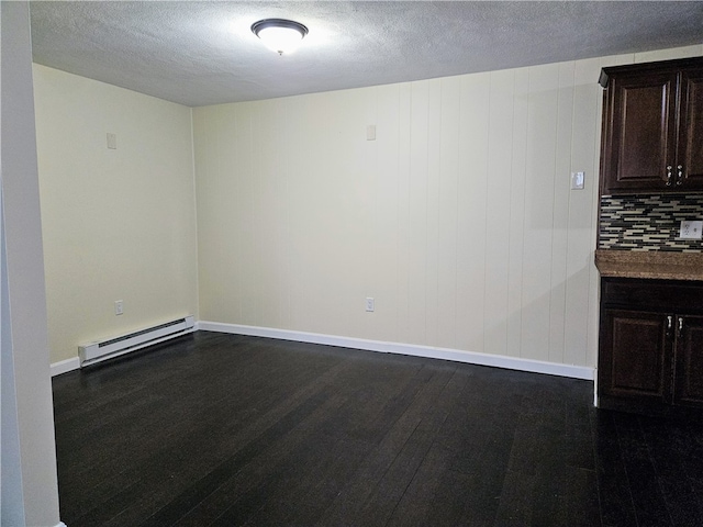 empty room with a textured ceiling, a baseboard radiator, and dark wood-type flooring