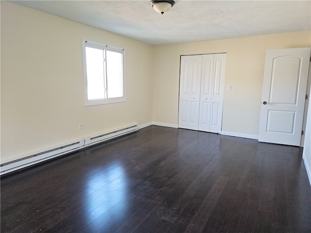 unfurnished bedroom featuring dark hardwood / wood-style floors, a closet, a textured ceiling, and a baseboard radiator