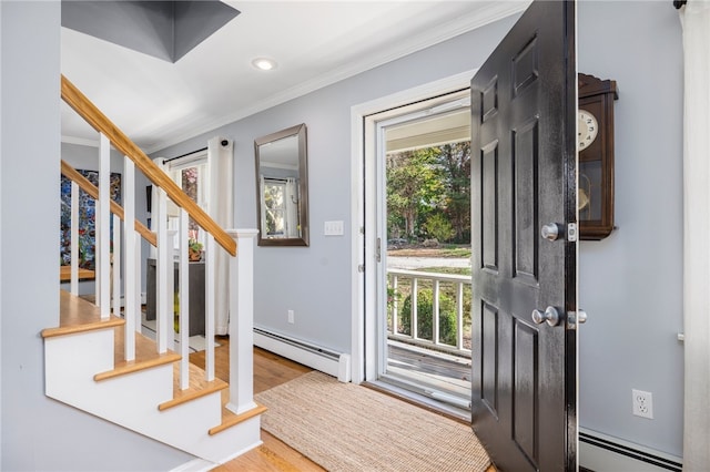 foyer featuring light hardwood / wood-style floors, a baseboard heating unit, and ornamental molding