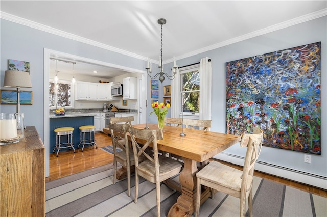 dining area with light wood-type flooring, a baseboard radiator, and crown molding