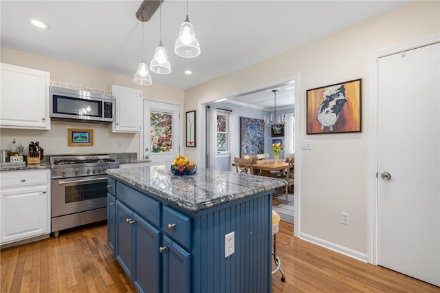 kitchen featuring stainless steel appliances, blue cabinetry, white cabinets, and light wood-type flooring