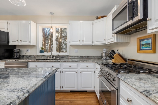 kitchen with white cabinets, stainless steel appliances, and light hardwood / wood-style flooring