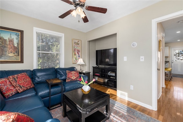 living room featuring wood-type flooring and ceiling fan