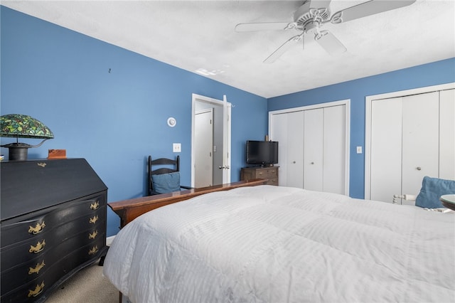 bedroom featuring carpet, multiple closets, and ceiling fan