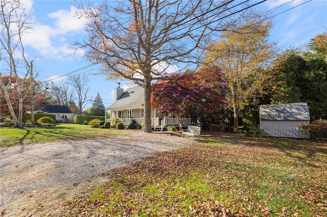 view of yard featuring a storage unit and covered porch