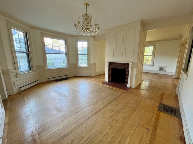 unfurnished living room featuring a brick fireplace, light hardwood / wood-style floors, a chandelier, and baseboard heating