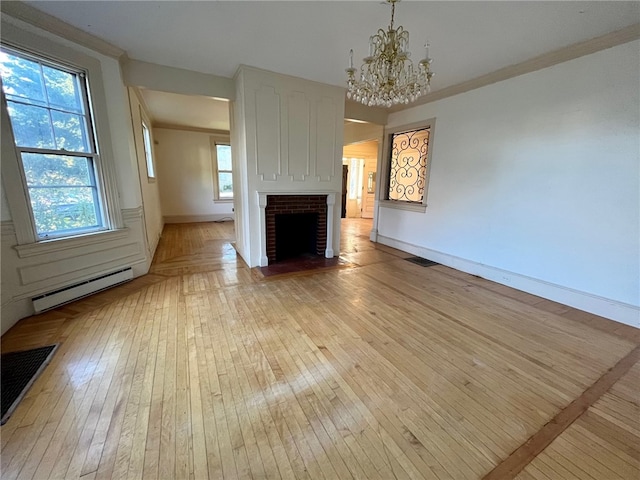 unfurnished living room featuring light wood-type flooring, a baseboard radiator, a chandelier, and crown molding