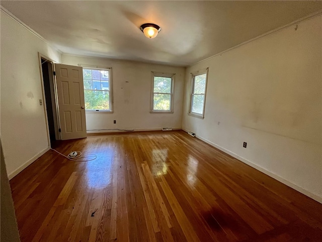 spare room with wood-type flooring and ornamental molding