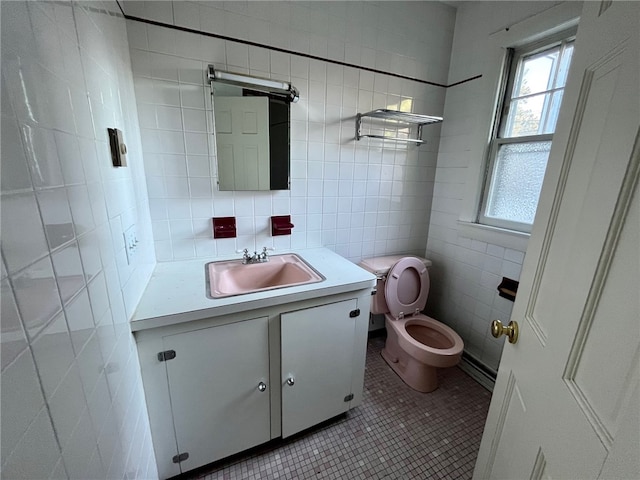 bathroom featuring toilet, tile patterned floors, tile walls, tasteful backsplash, and vanity