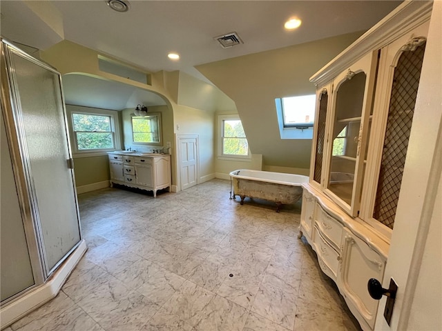 bathroom featuring a skylight, separate shower and tub, vanity, and plenty of natural light