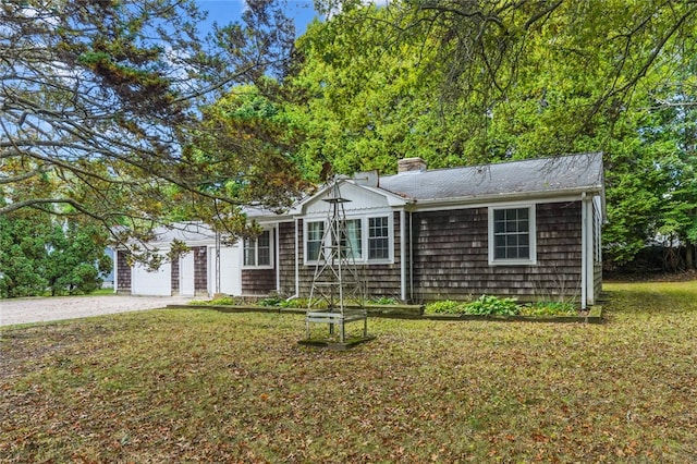 ranch-style home with a garage and a front lawn