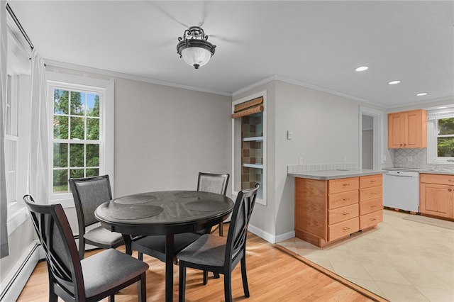 dining space with a baseboard heating unit, light hardwood / wood-style flooring, a healthy amount of sunlight, and crown molding