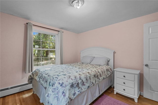 bedroom featuring a baseboard radiator and hardwood / wood-style flooring