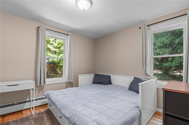 bedroom featuring light wood-type flooring and a baseboard radiator