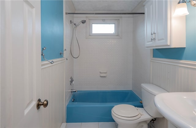 full bathroom with tile patterned floors, tiled shower / bath combo, toilet, and sink