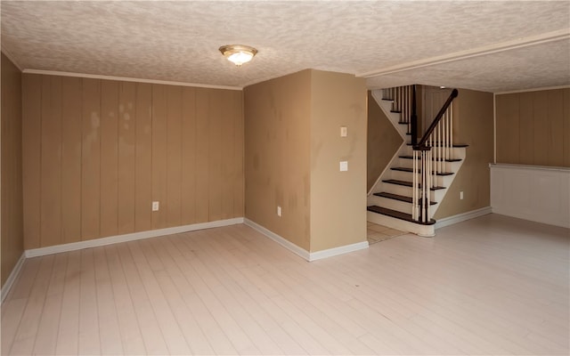 interior space featuring wood walls, wood-type flooring, and a textured ceiling