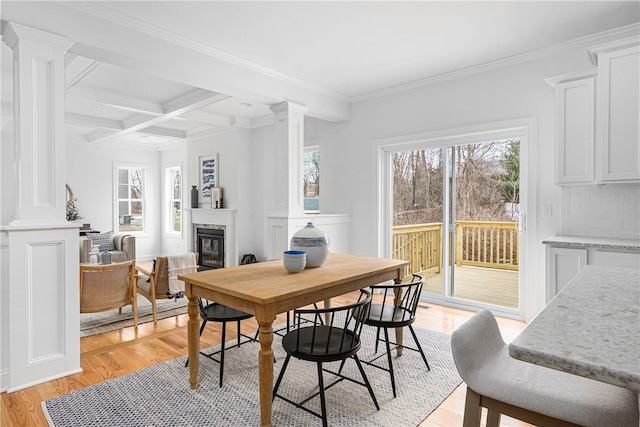 dining area featuring ornamental molding, coffered ceiling, decorative columns, beamed ceiling, and light hardwood / wood-style flooring