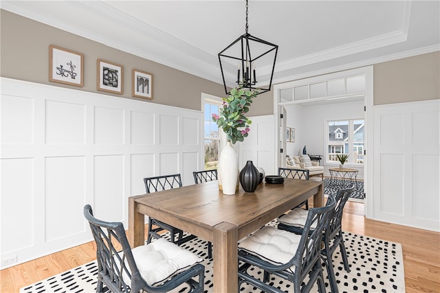 dining room with light wood-type flooring, a notable chandelier, and ornamental molding