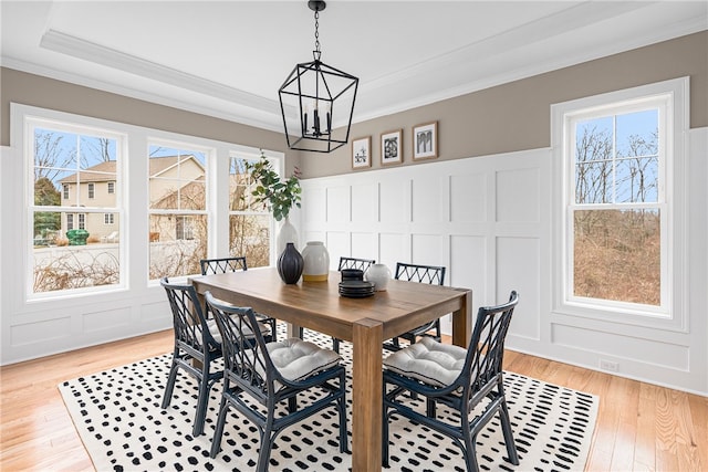 dining space featuring a wealth of natural light, a notable chandelier, crown molding, and light hardwood / wood-style flooring