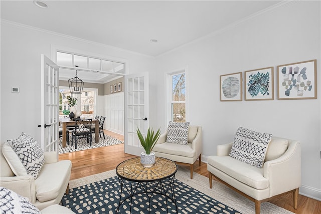 living area with a wealth of natural light, wood-type flooring, and french doors