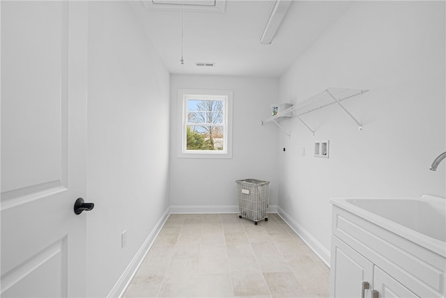 washroom with cabinets, washer hookup, and sink