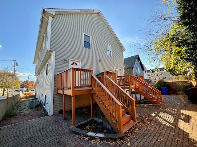 rear view of property featuring a patio area, central air condition unit, and a deck