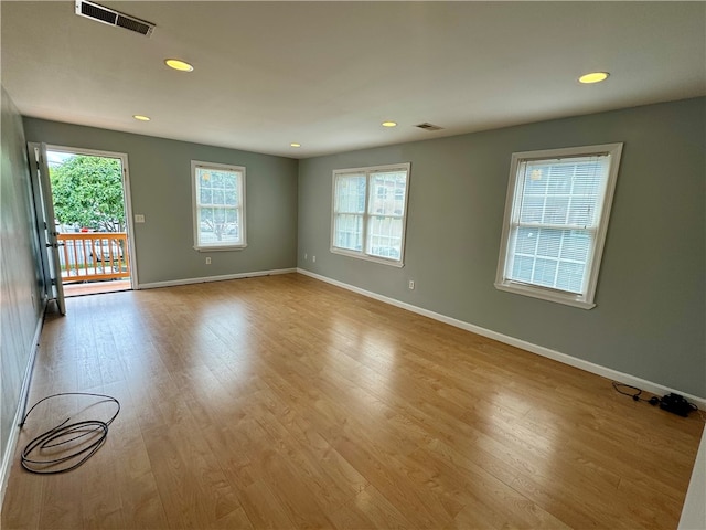 empty room featuring plenty of natural light and light hardwood / wood-style flooring