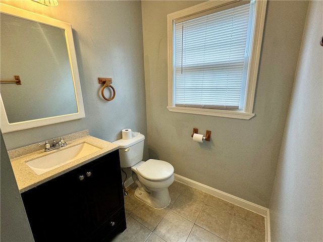 bathroom featuring vanity, plenty of natural light, tile patterned flooring, and toilet