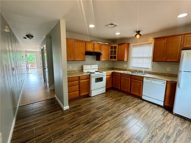 kitchen featuring sink, dark wood-type flooring, and white appliances