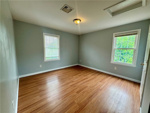 spare room with light wood-type flooring and a healthy amount of sunlight