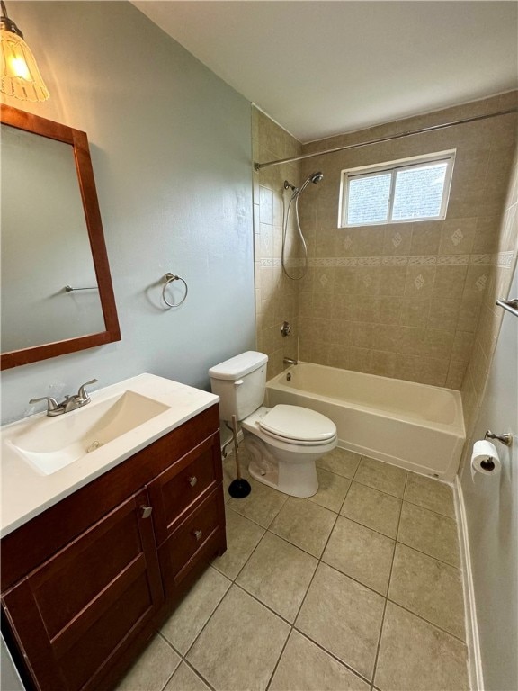 full bathroom with tile patterned floors, vanity, tiled shower / bath, and toilet