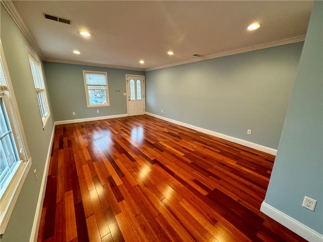 empty room with hardwood / wood-style floors and ornamental molding