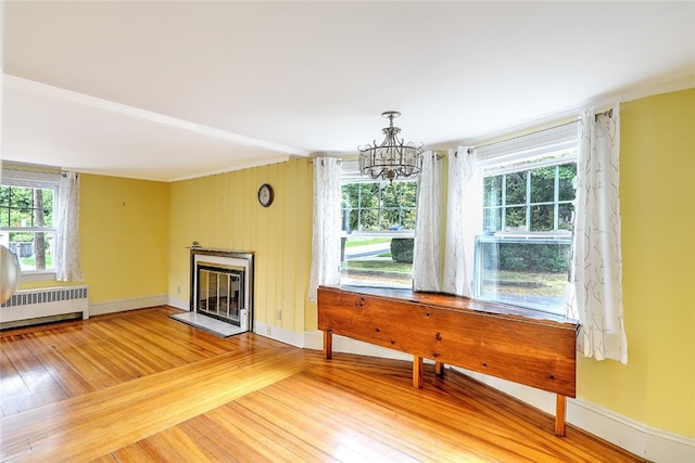 interior space with radiator heating unit, hardwood / wood-style flooring, and an inviting chandelier