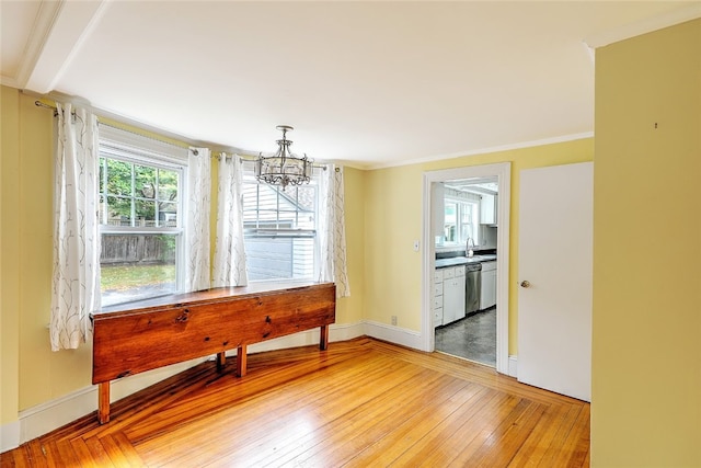 dining room featuring wood-type flooring, sink, an inviting chandelier, and ornamental molding