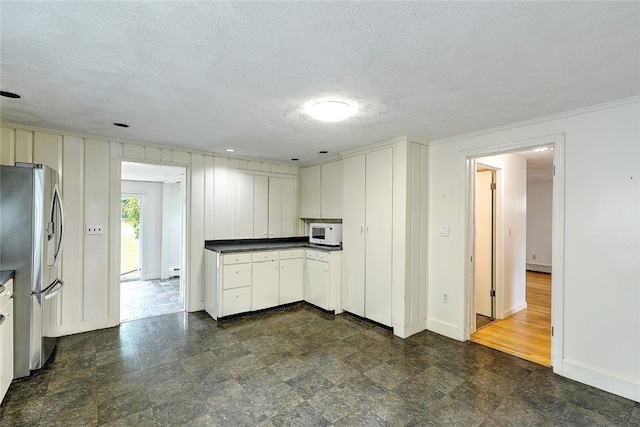 kitchen featuring dark wood-type flooring, white cabinetry, a textured ceiling, and stainless steel fridge