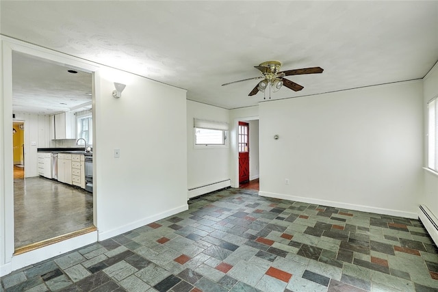 spare room with ceiling fan and a baseboard heating unit