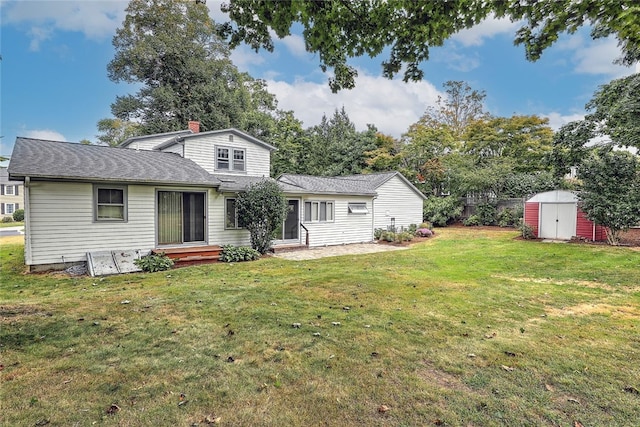 rear view of house with a yard and a shed