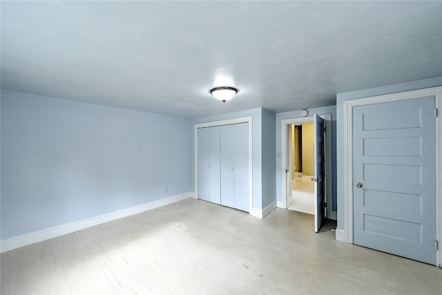 unfurnished bedroom with light hardwood / wood-style floors and a closet