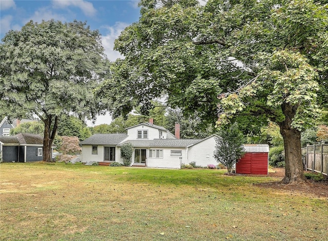 view of front facade featuring a storage shed and a front yard