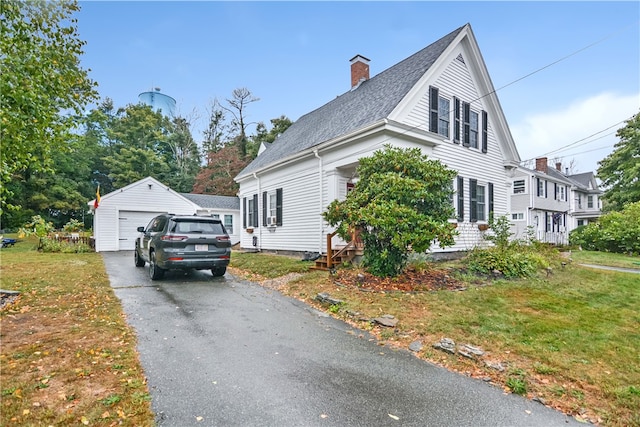 view of front facade with a garage, an outdoor structure, and a front lawn