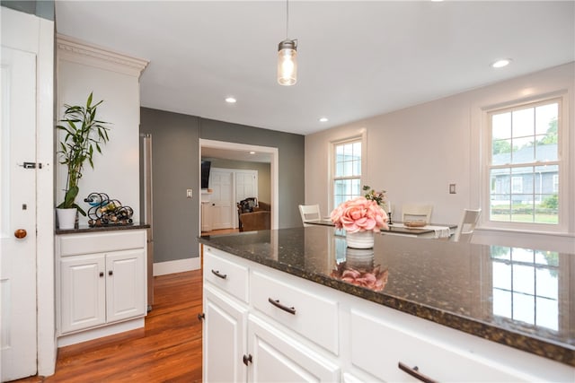 kitchen featuring white cabinets, plenty of natural light, and decorative light fixtures