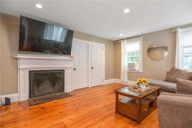 living room with cooling unit, light hardwood / wood-style floors, and plenty of natural light