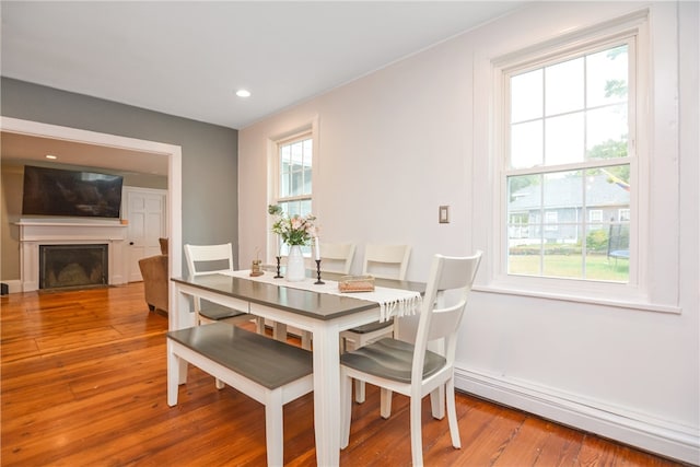 dining space with wood-type flooring and baseboard heating