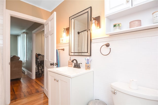 bathroom with tile walls, crown molding, vanity, hardwood / wood-style flooring, and toilet