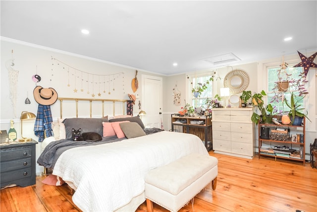 bedroom featuring light wood-type flooring and crown molding