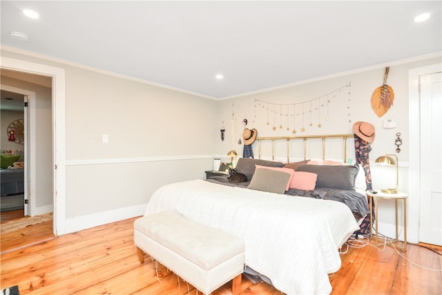 bedroom featuring crown molding and light hardwood / wood-style flooring