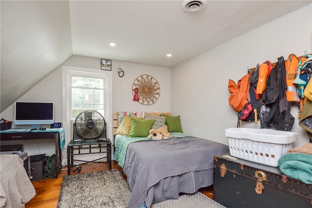 bedroom with vaulted ceiling and hardwood / wood-style flooring