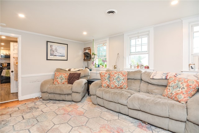 living room featuring a healthy amount of sunlight, ornamental molding, and hardwood / wood-style flooring